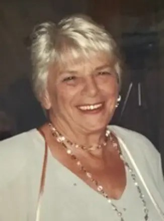 Joan Martin smiling warmly, wearing a beaded necklace